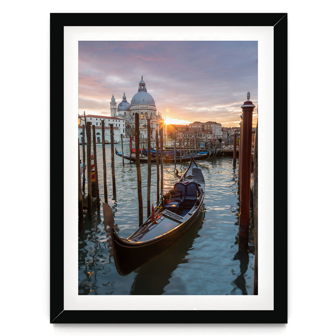 a gondola boat floating on the water, with a picturesque view of the city skyline and the sun setting in the background.