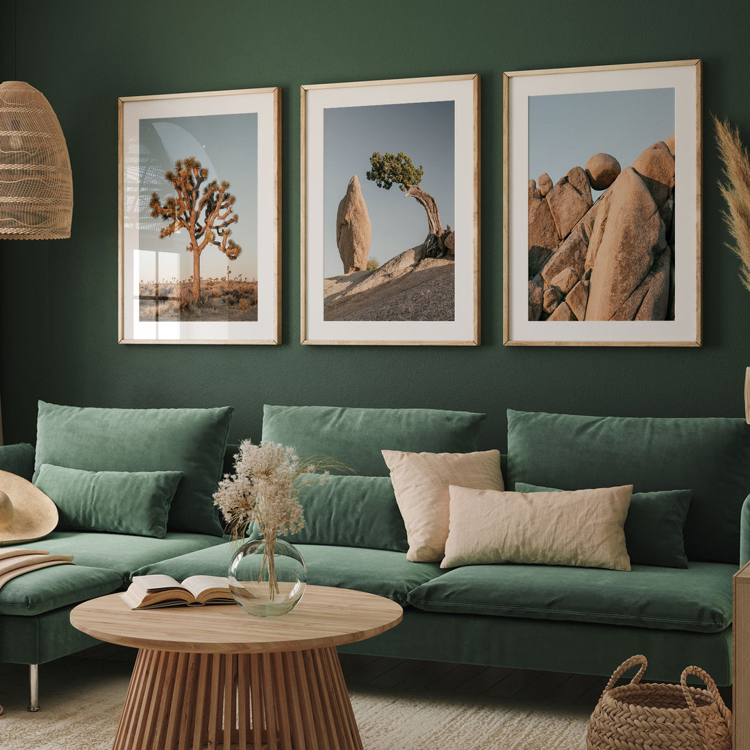 a living room with a green couch and two pictures on the wall