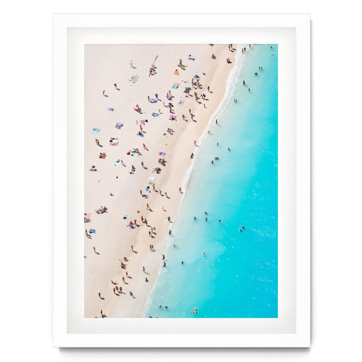 a crowded beach with people enjoying the sun and sand, with the ocean visible in the background.