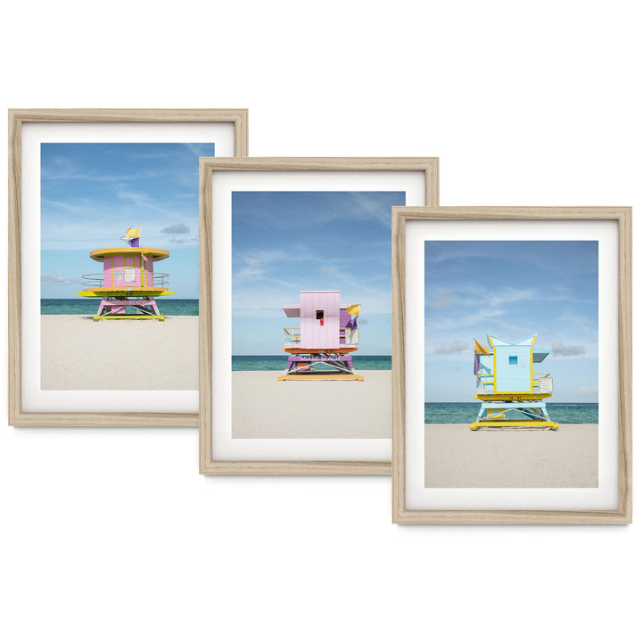 The image is a collage of three framed pictures, each depicting a lifeguard tower on a beach. The lifeguard towers are painted in various colors, including pink, yellow, and blue, and are situated on the sandy beach against a backdrop of the ocean.