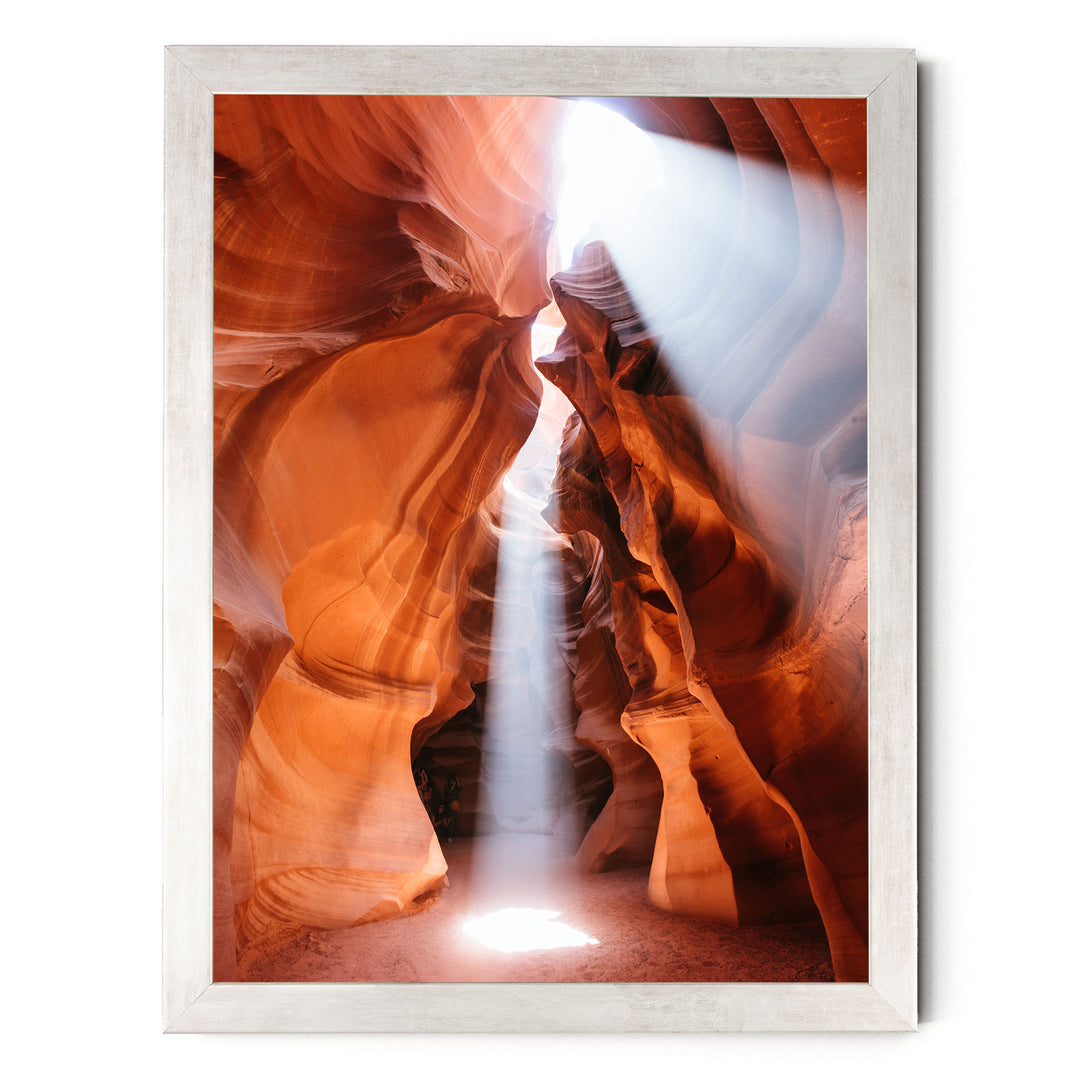a stunning natural rock formation with a bright light shining through the narrow passage, creating a dramatic and captivating scene.