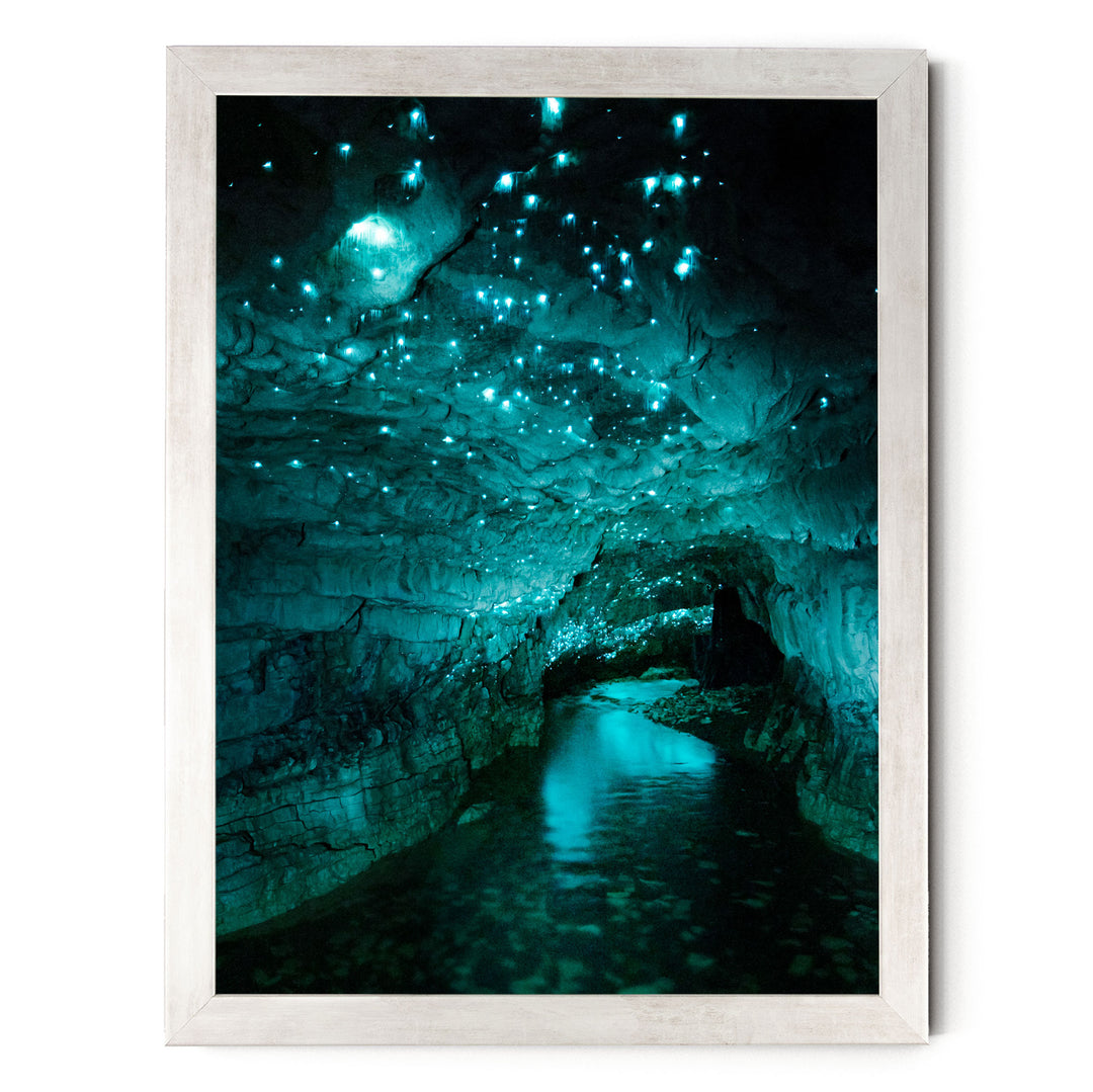 A stunning cave with a pool of water at its center, surrounded by a mesmerizing display of glowing blue and green lights that illuminate the cave's interior.