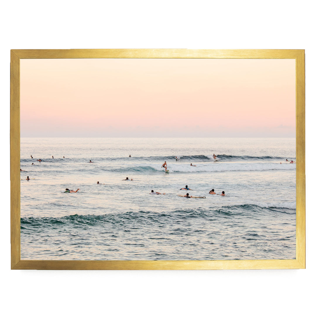 a group of people enjoying themselves in the ocean, with some swimming and others surfing on the waves.