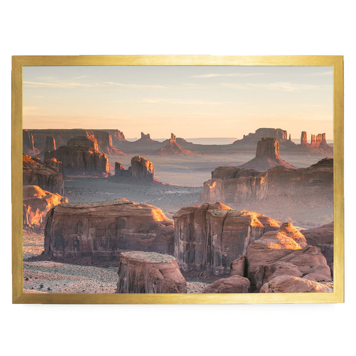 a breathtaking view of the Grand Canyon, with its vast, rugged landscape stretching out beneath a warm, golden sunset. The canyon's towering rock formations and deep crevices create a dramatic and awe-inspiring scene, showcasing the natural beauty of the region.
