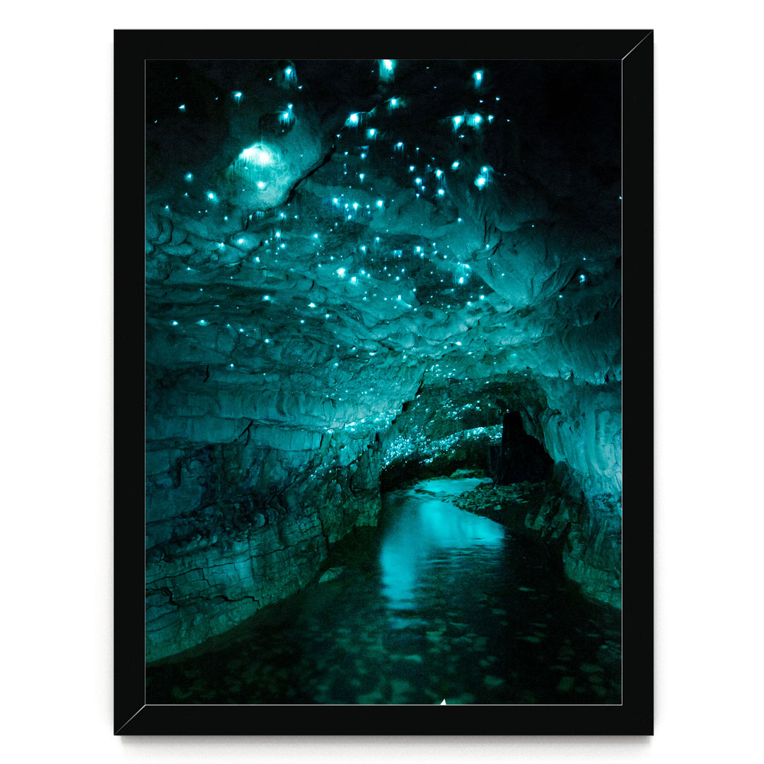 A cave with a stream of water flowing through it, illuminated by a mesmerizing display of blue and green lights that create a captivating, otherworldly atmosphere.