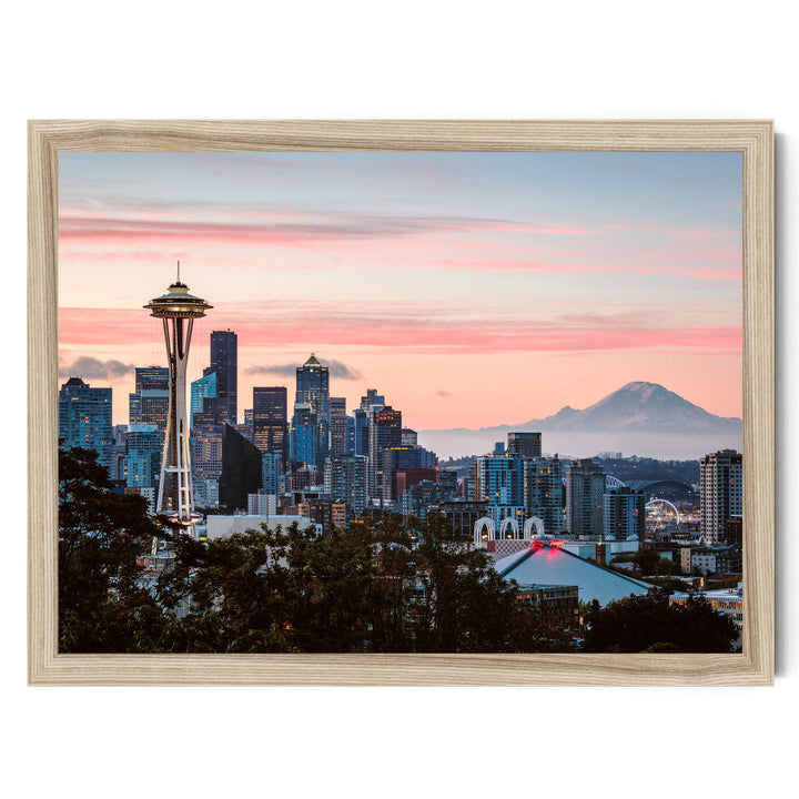 a city skyline at sunset, with the Space Needle and other high-rise buildings silhouetted against a vibrant pink and orange sky.