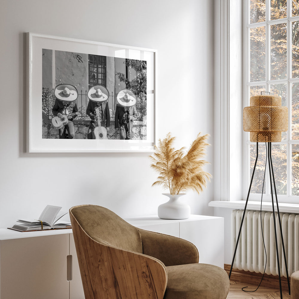a modern living room with a large framed black and white photograph of three people playing musical instruments hanging on the wall. The room is decorated with a wooden chair, a potted plant, and a floor lamp, creating a cozy and inviting atmosphere.