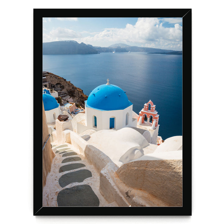a picturesque view of a Greek island with white buildings and blue domes overlooking the ocean.