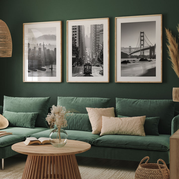a living room with a green sofa, a wooden coffee table, and three framed black and white photographs of iconic cityscapes hanging on the wall.