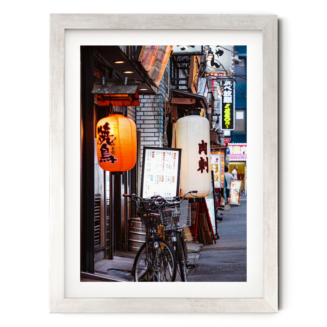 a vibrant street scene in Japan, with colorful lanterns hanging from the buildings and a bicycle parked on the sidewalk.
