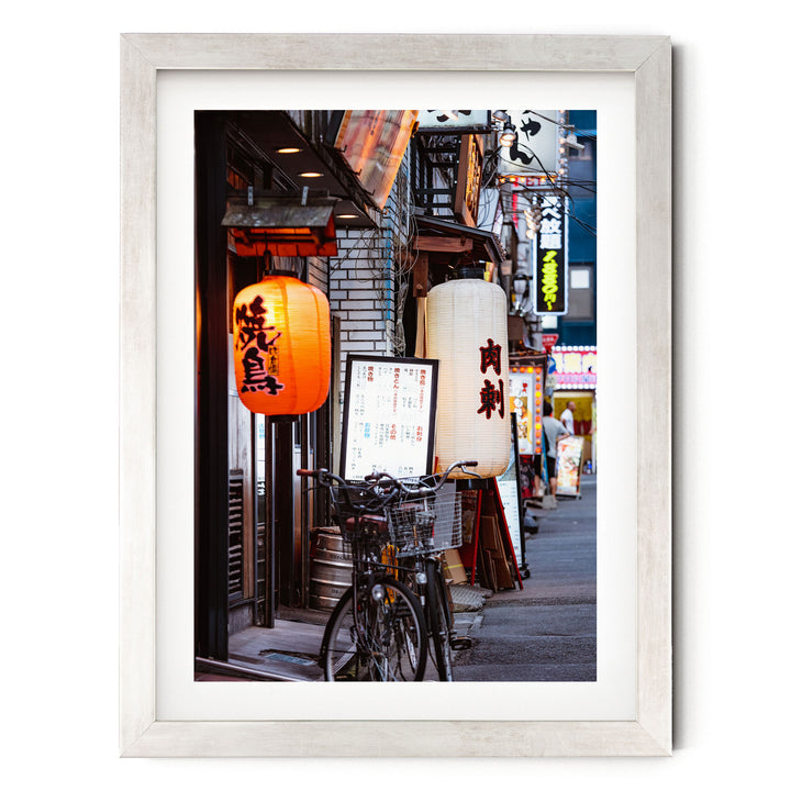 a vibrant street scene in Japan, with colorful lanterns hanging from the buildings and a bicycle parked on the sidewalk.