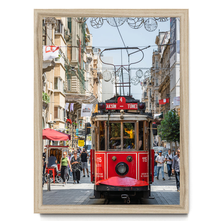 A red trolley car is traveling down a busy street in Istanbul, Turkey, surrounded by pedestrians and other vehicles.