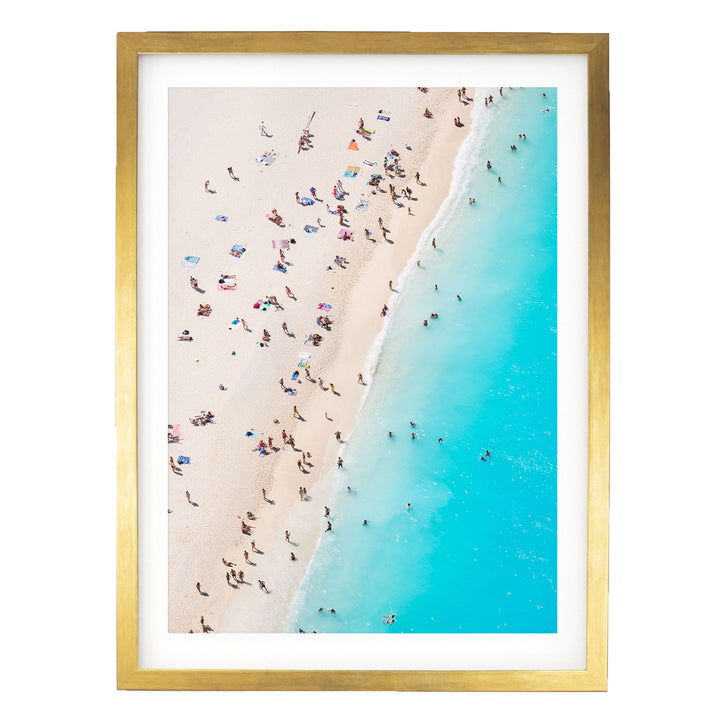 The image is a framed photograph of a beach scene with people enjoying the sun and water.